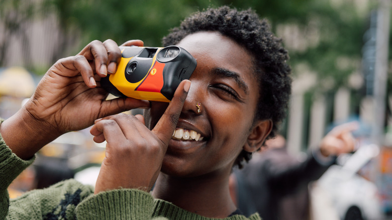 A traveler in New York City uses a disposable camera